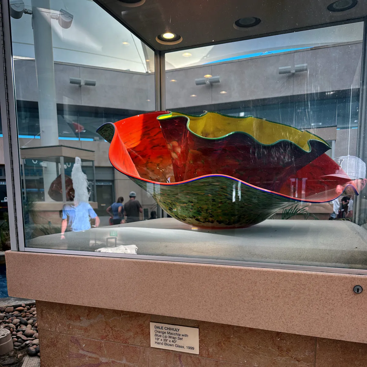 Large multicolor glass bowl by Dale Chihuly in a display case