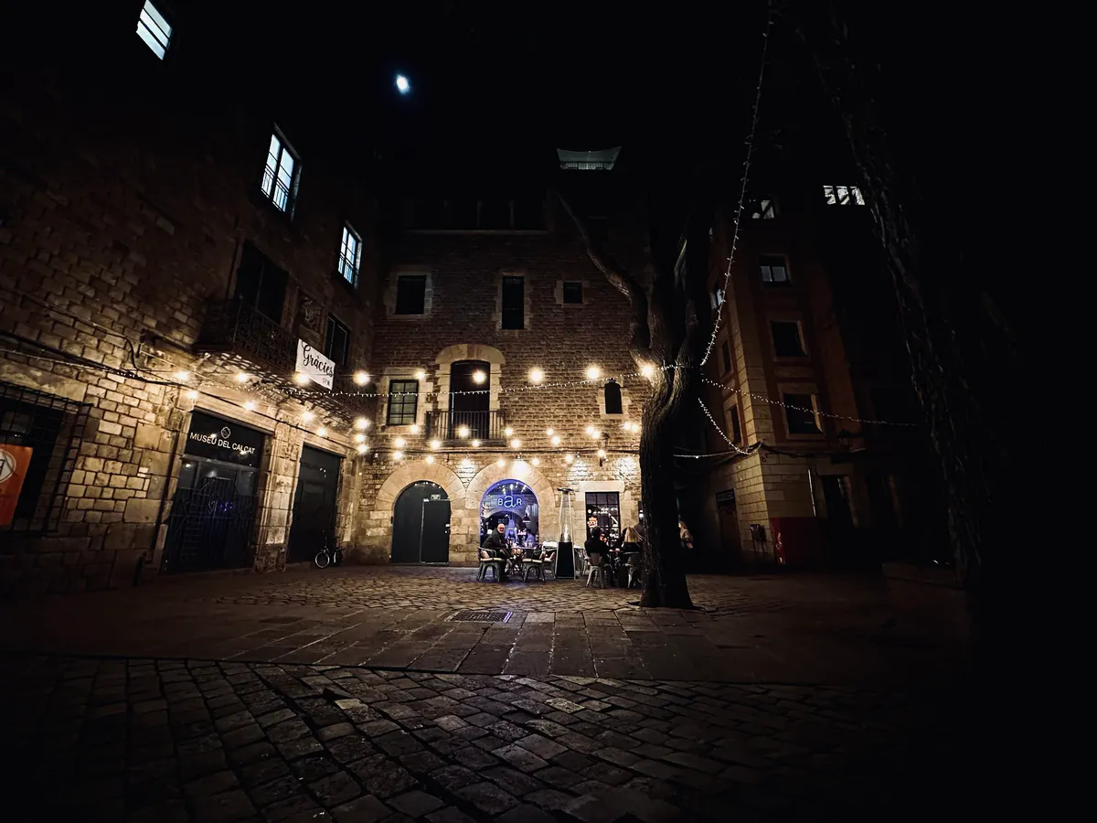 Night square with string lights outside the Museu del Calçat