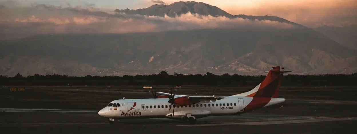 Avianca propeller plane on the tarmac with mountains behind
