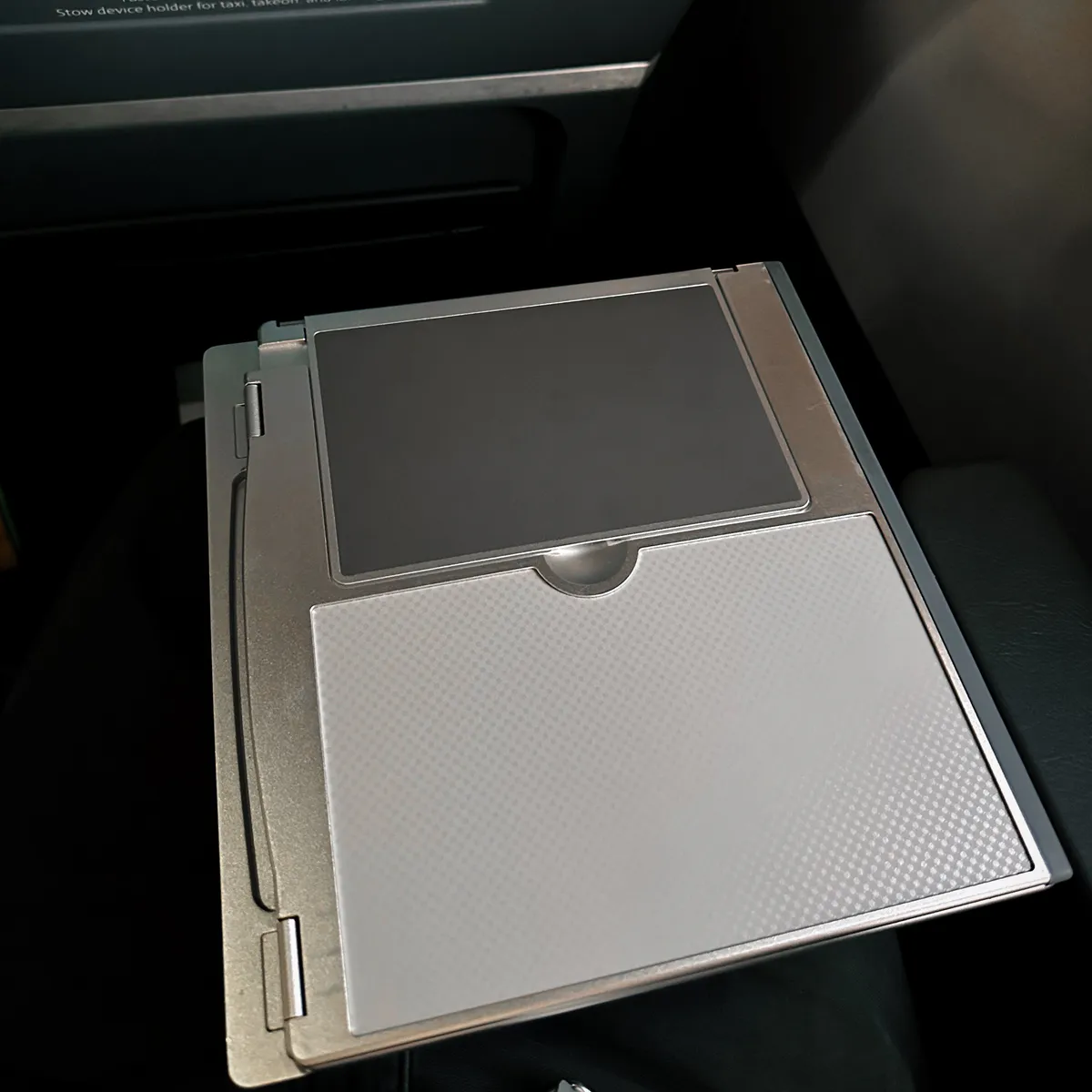 Folded airplane tray table with the device holder lying flat