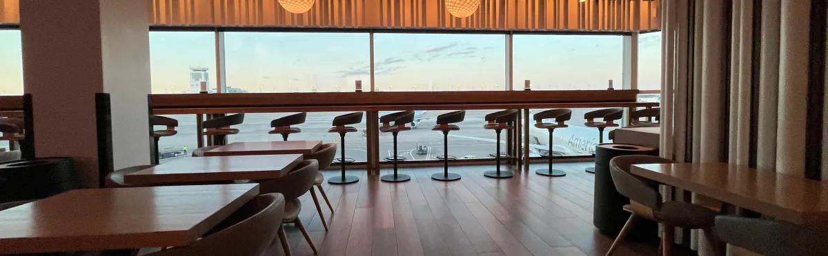 Airport lounge bar stools facing a tarmac and an American jet
