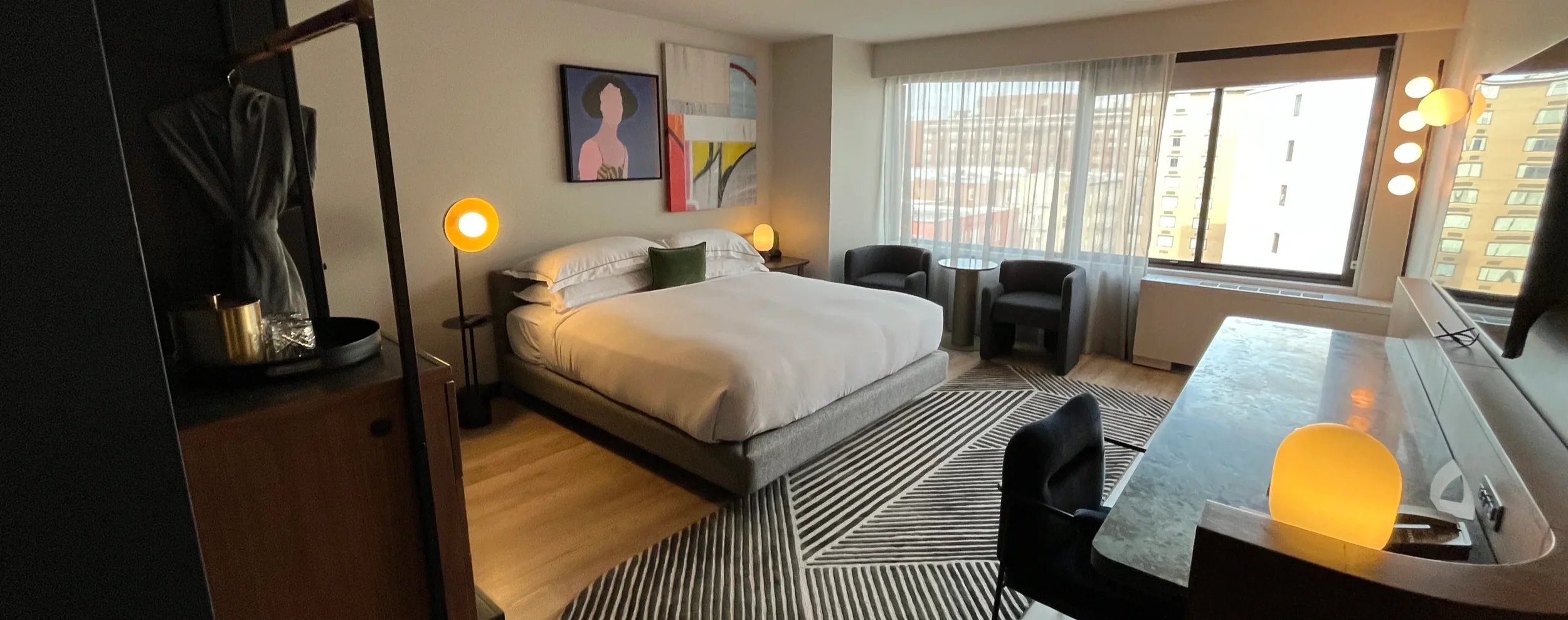 Modern hotel bedroom with a large bed and a city view