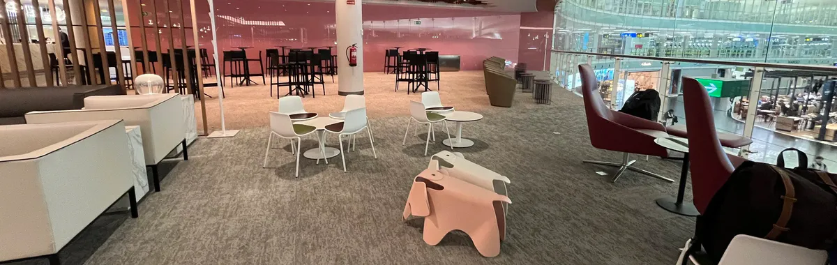 Airport lounge with white chairs and pink animal-shaped stools