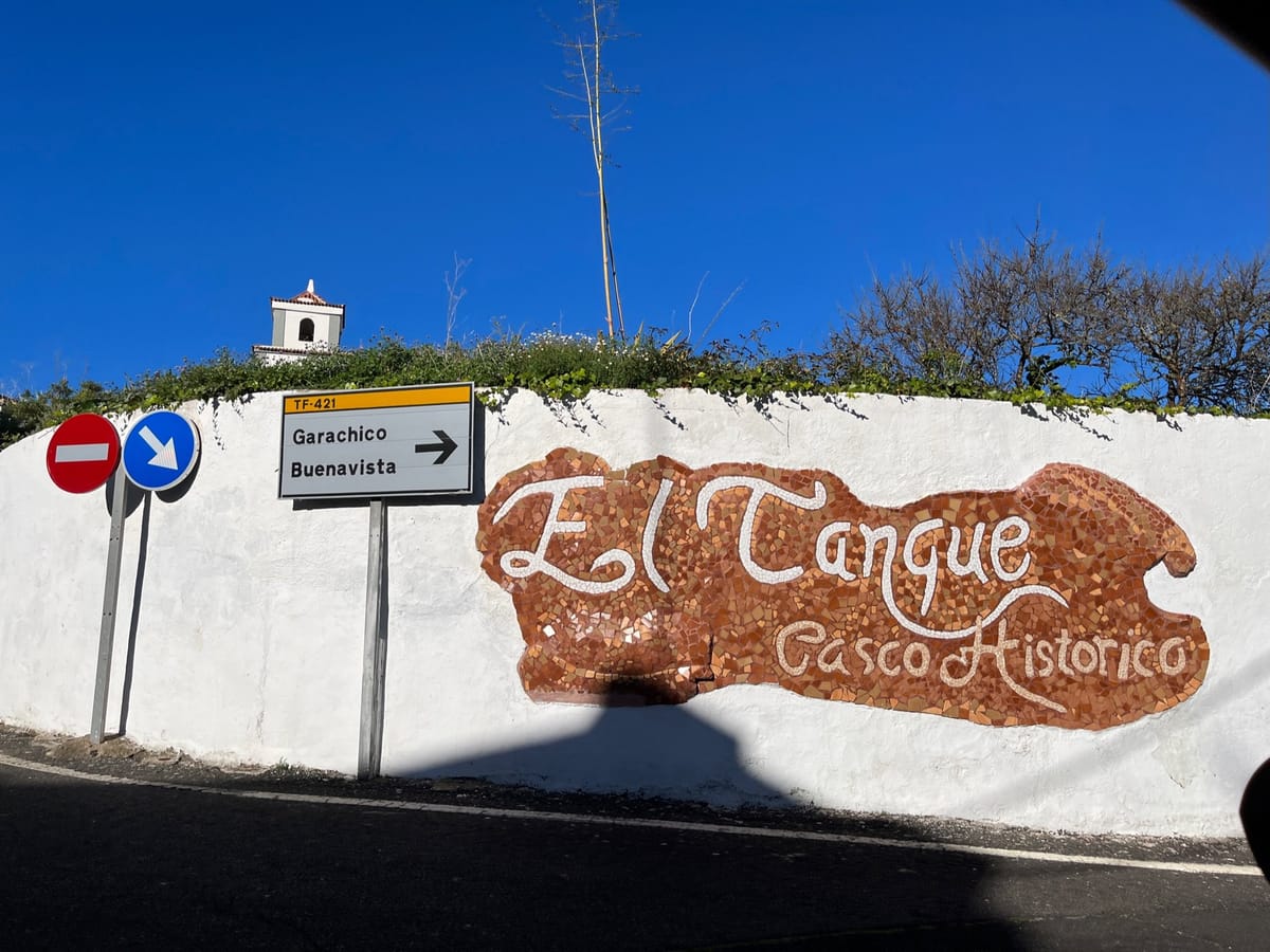 Road signs pointing to Garachico beside a mosaic reading El Tanque Casco Historico.