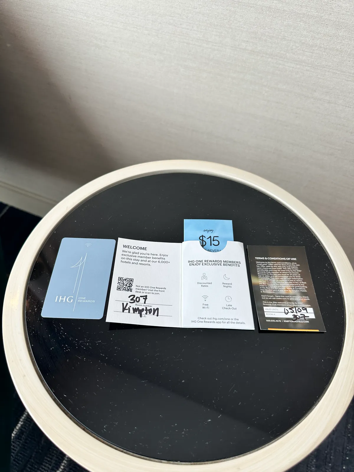 Key card, welcome note, and beverage credit laid on a round black table