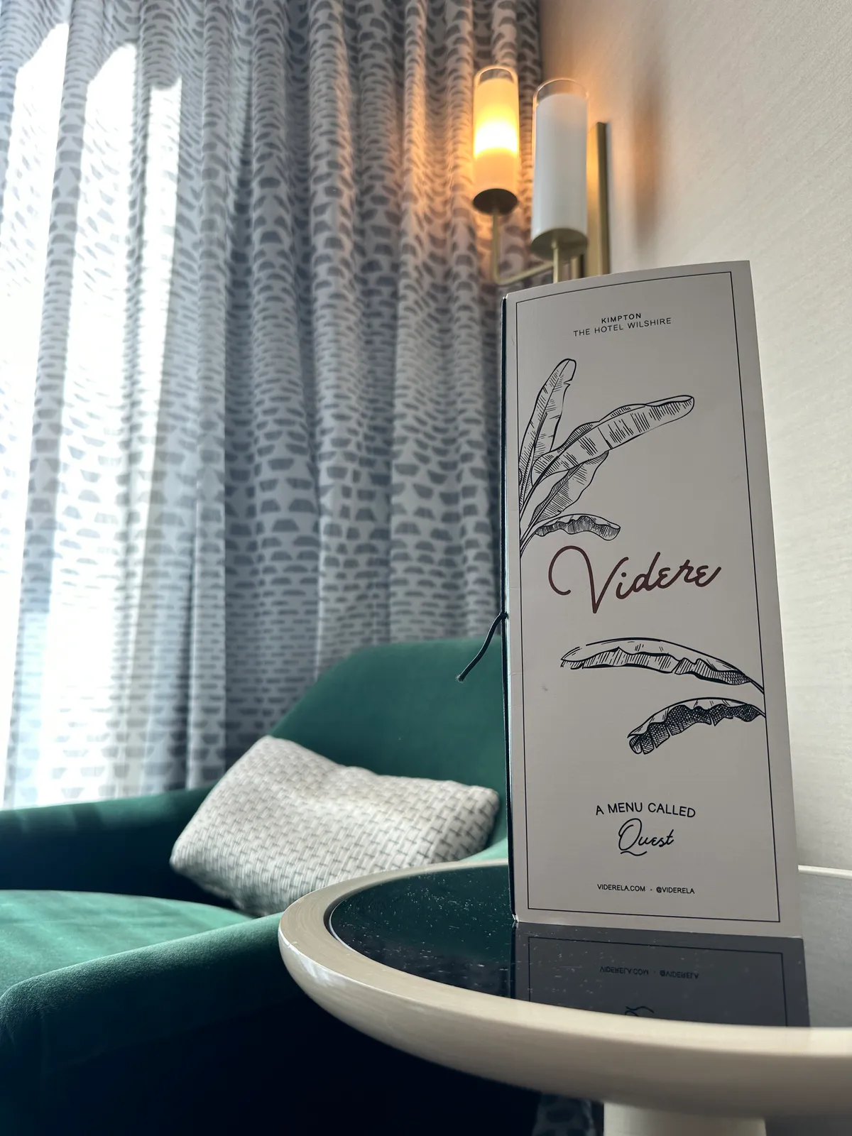 Standing Videre menu card on a glass table next to a green chair