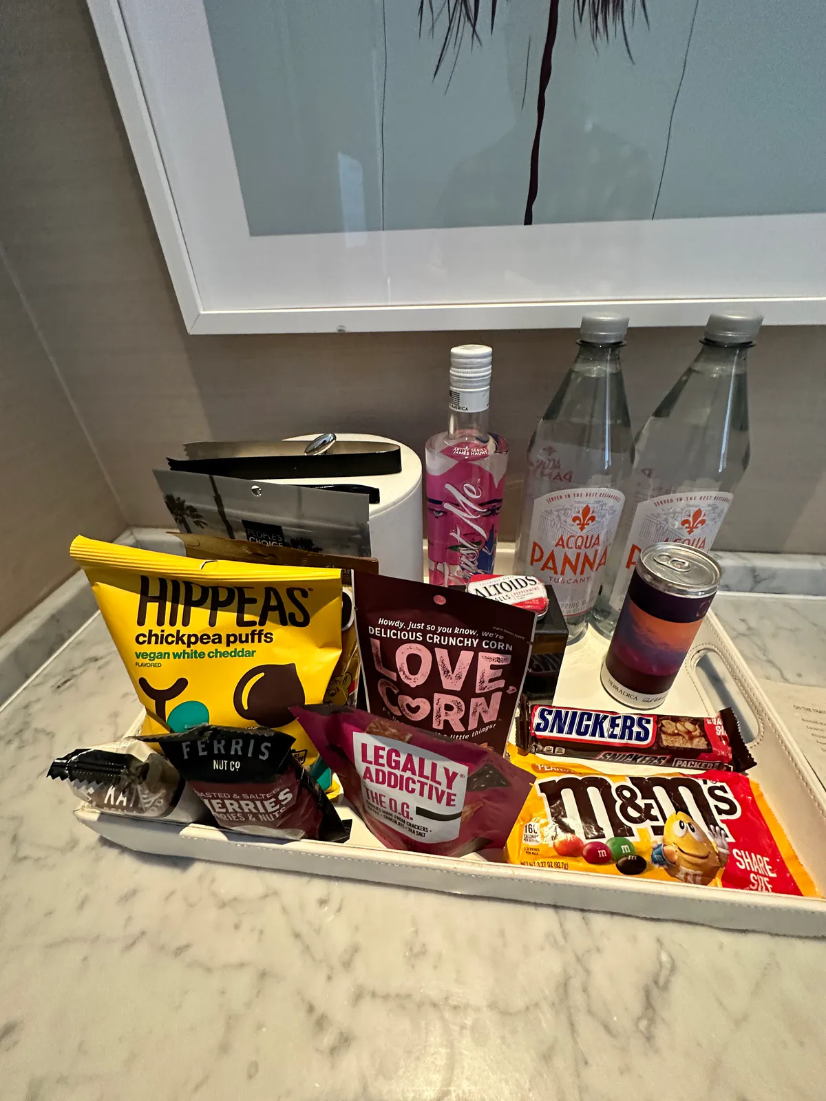 Snack tray of chips, candy, and water bottles on a marble counter