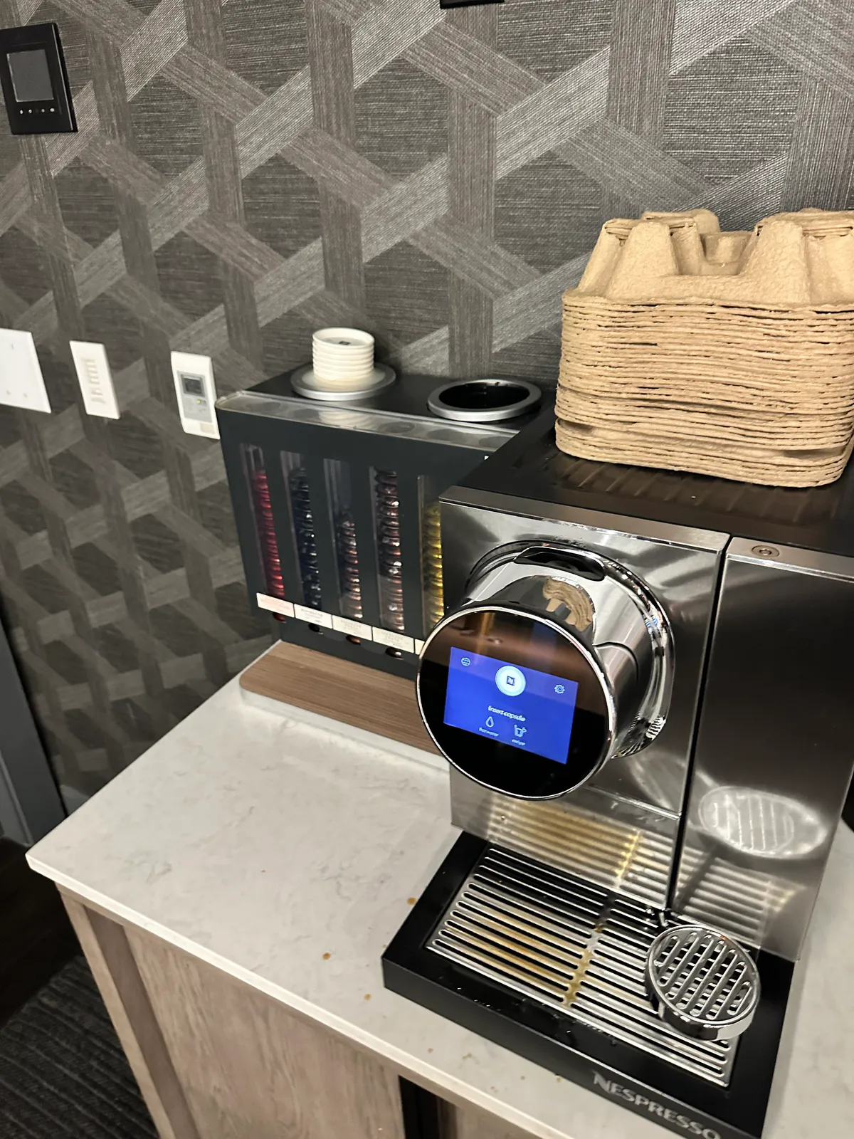 Closer side view of the Nespresso machine and rows of coffee capsules