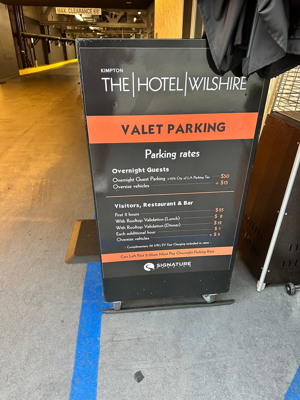 Close view of a black valet parking rates board in the garage