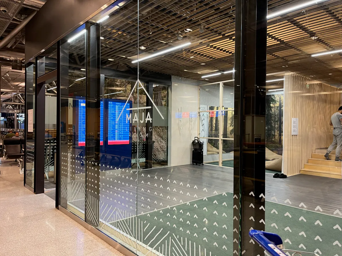 Glass entrance to the Maja Living Room, with forest murals visible inside