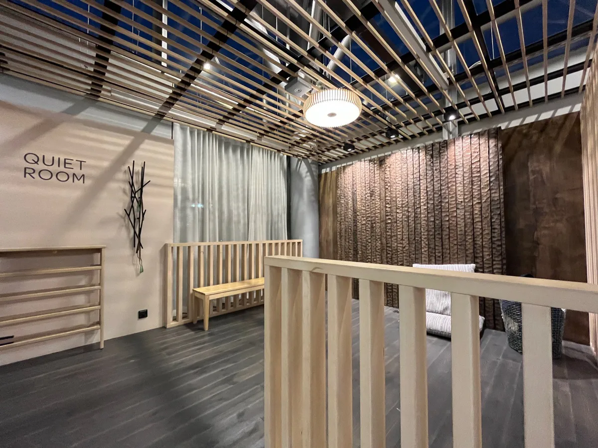 A Quiet Room with a wooden bench, slatted ceiling, and textured wood wall