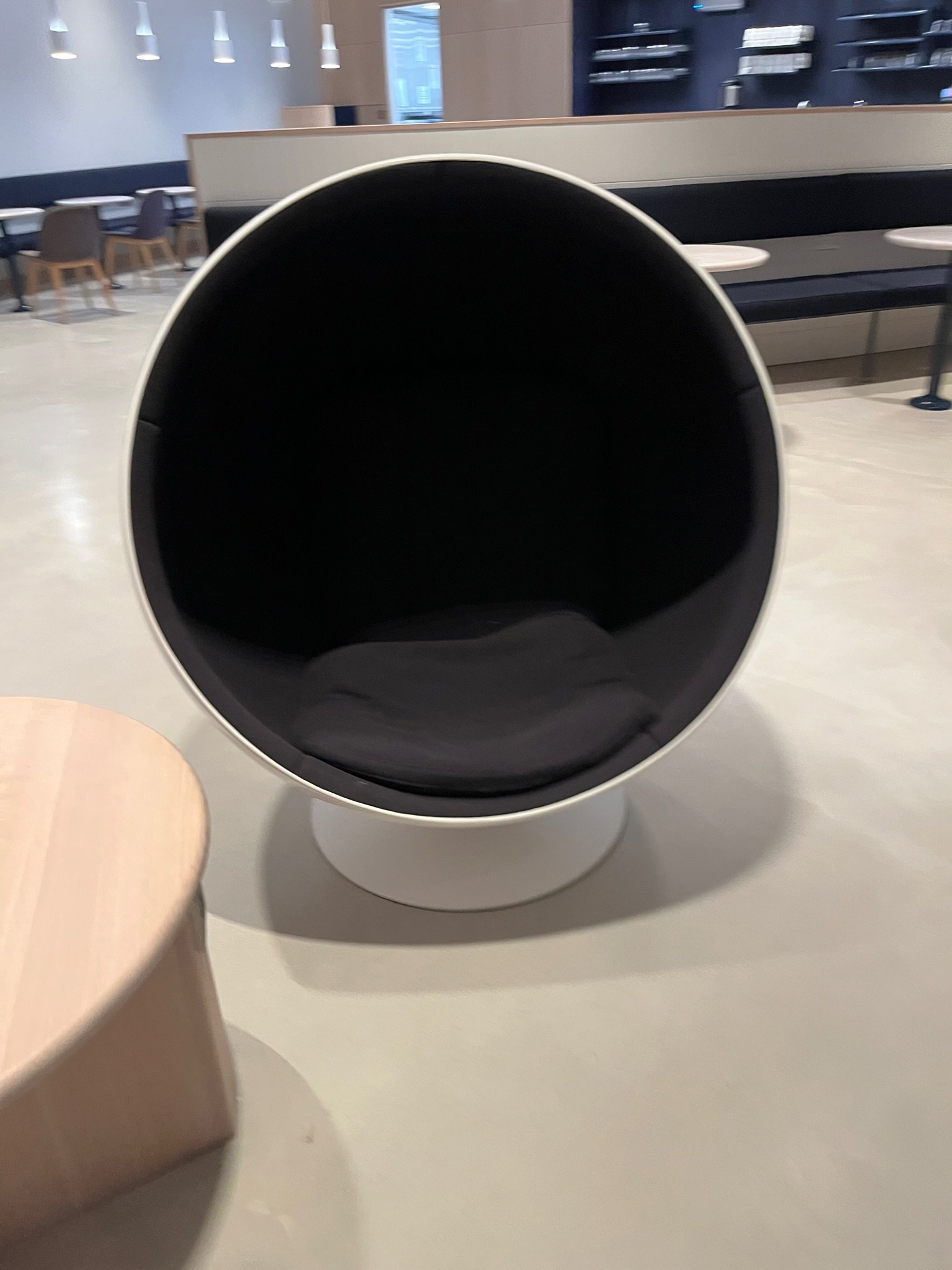 A close view of a white spherical chair with a black cushioned interior