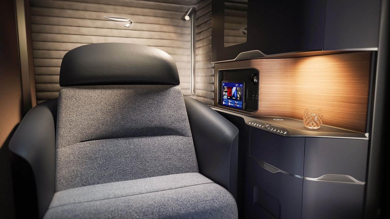 Gray British Airways first class seat by a wood console