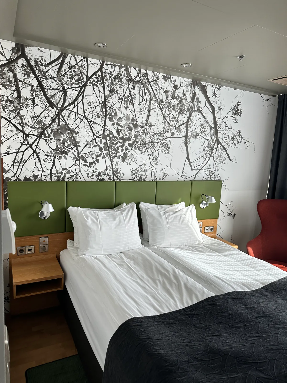 Holiday Inn Helsinki bed with white linens and a tree mural