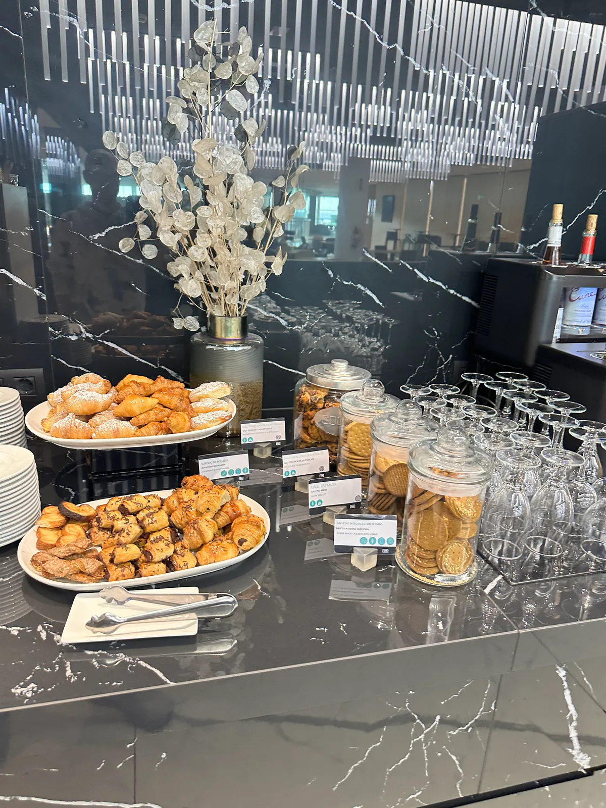 Lounge pastry plates, biscuit jars, stacked glasses, and a eucalyptus vase