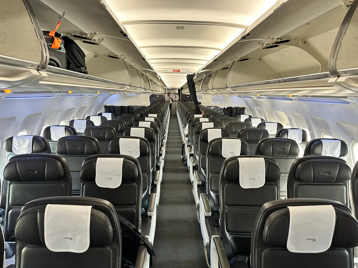 Wide view down the British Airways cabin toward the rear exit sign