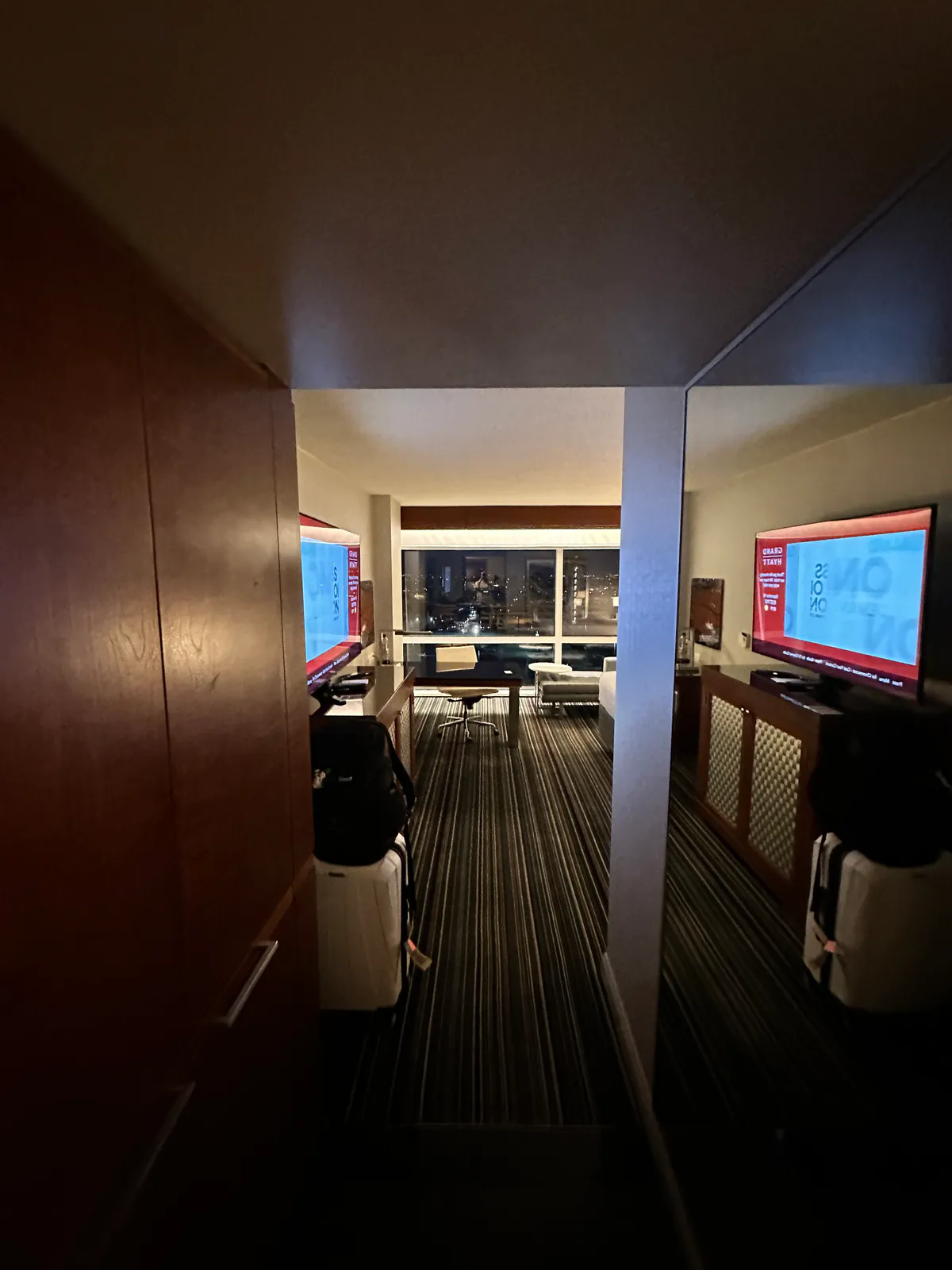 Grand Hyatt DFW doorway view with luggage, a desk, and a television