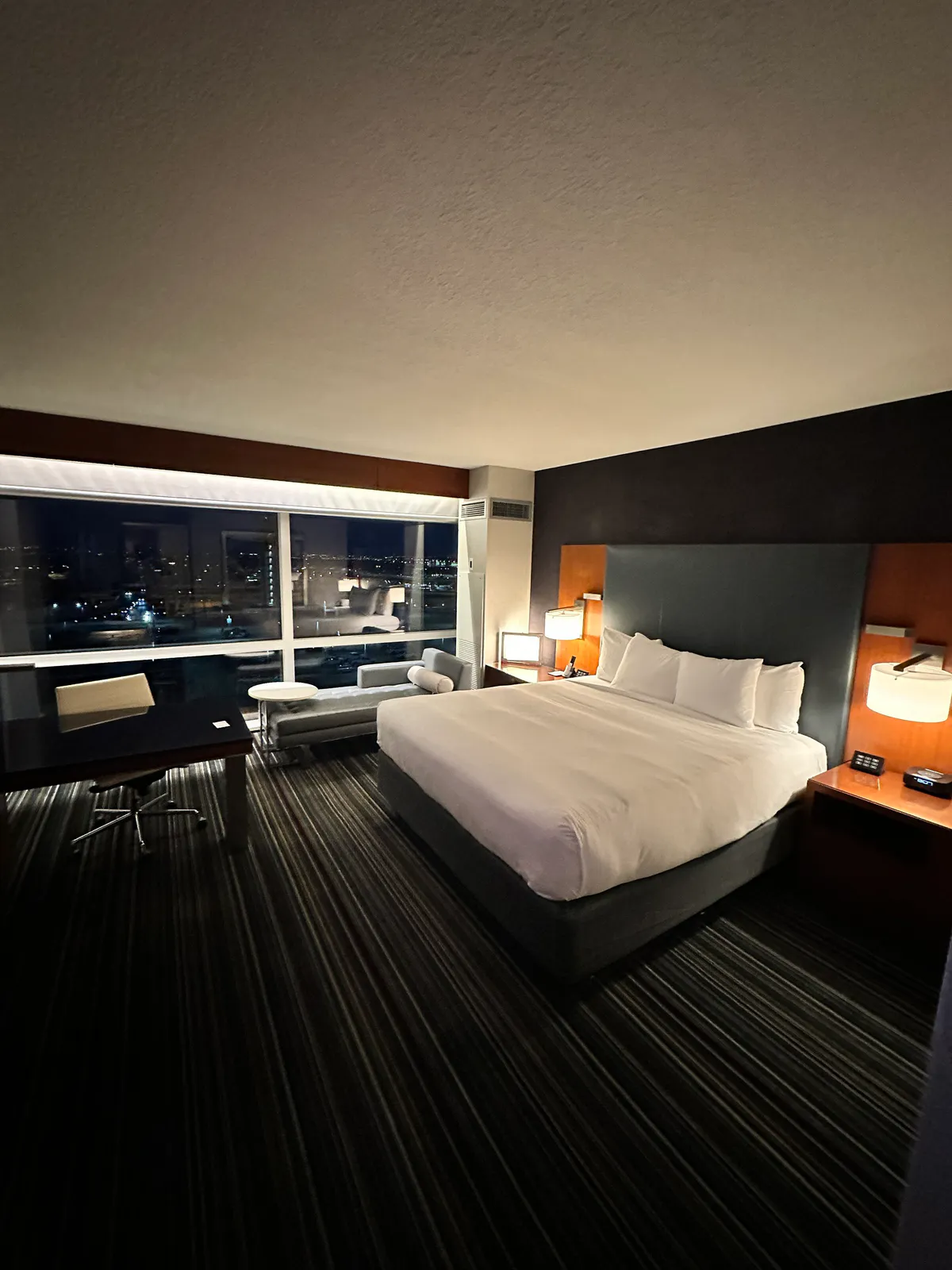 Large white bed in a dark Grand Hyatt DFW room at night