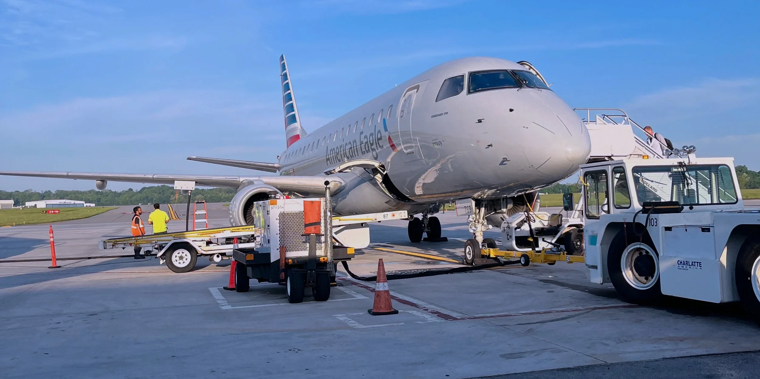 American Eagle jet parked on the tarmac beside ground equipment