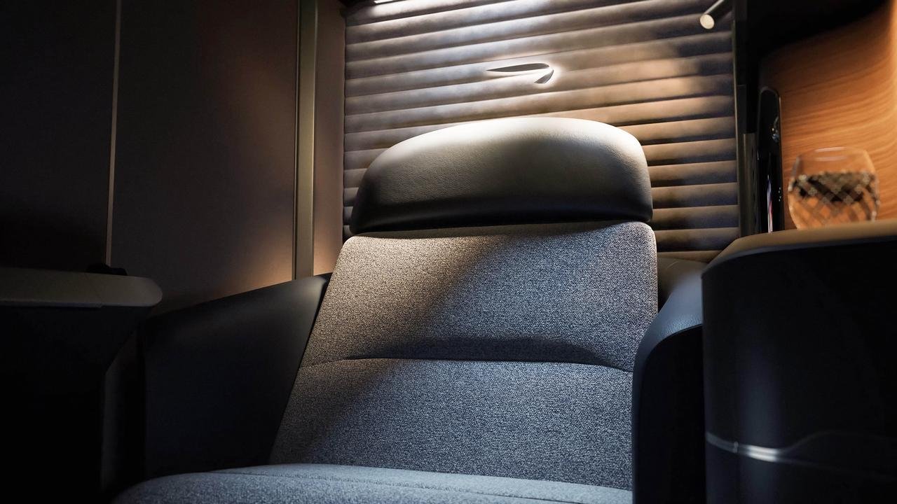 Gray British Airways first class seat with a black headrest and reading light