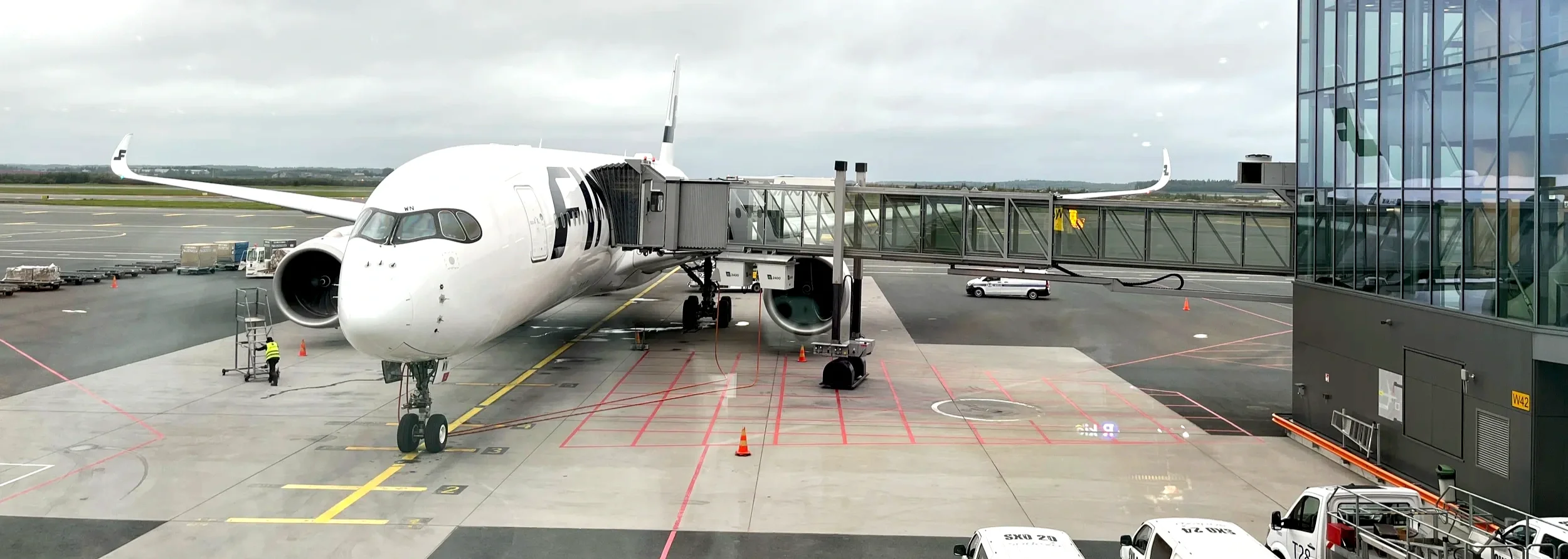 Finnair jet parked at a gate beside a glass terminal